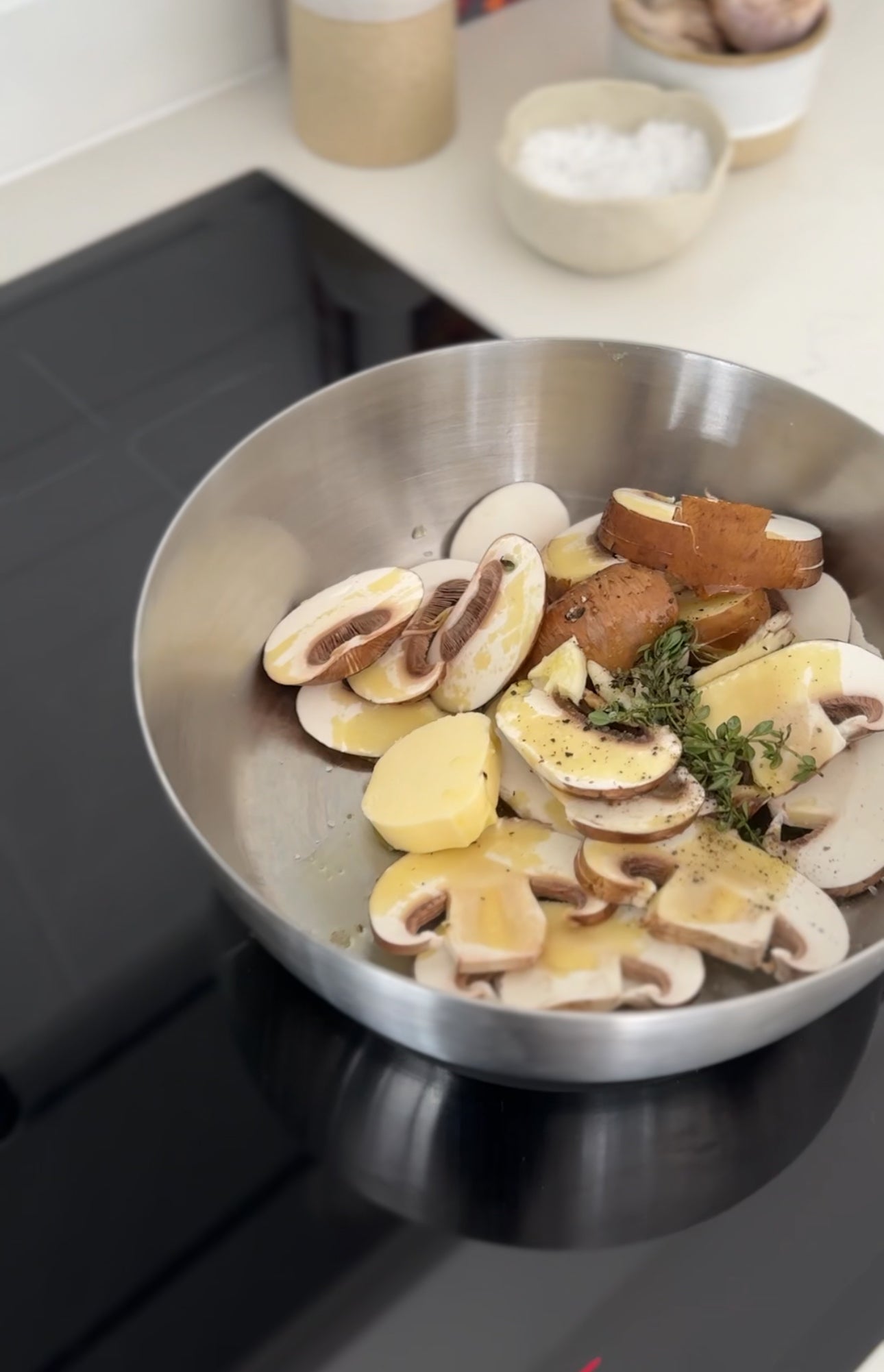Picture of mushrooms and herbs in a saute pan in Simone's cooking workshop