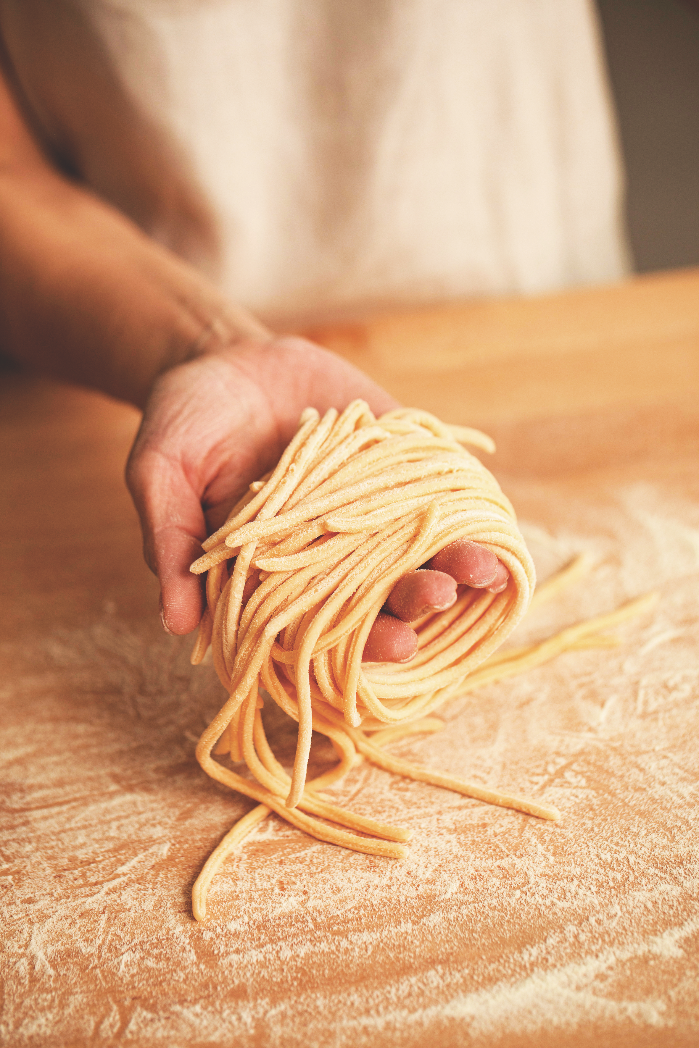 Picture of hand holding freshly shaped egg pasta tonarelli