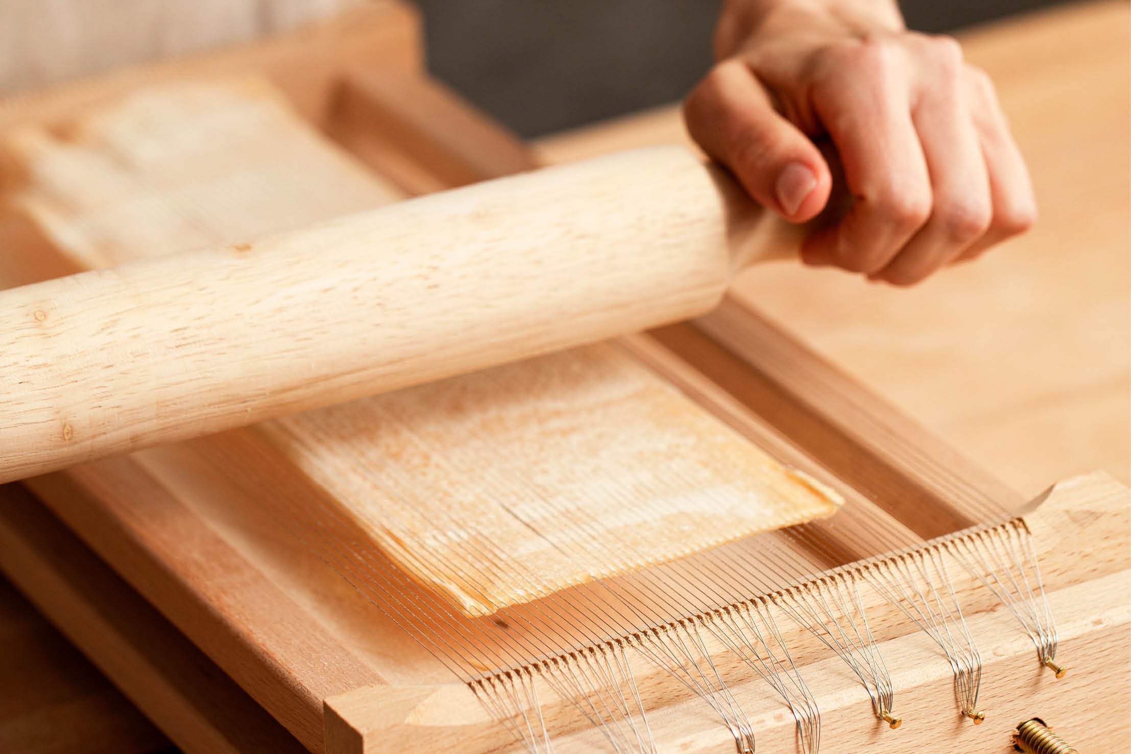 Rolling fresh pasta on a chitarra